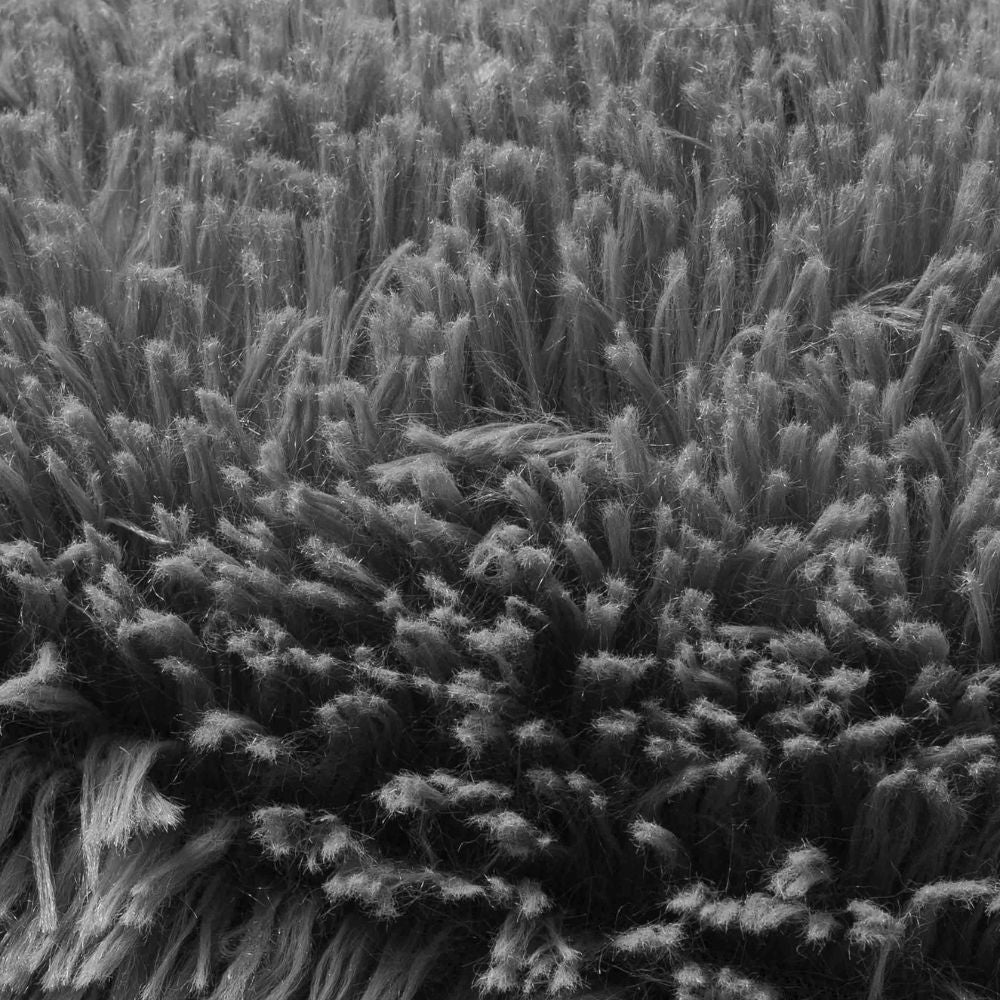 Detalle del tejido shaggy suave en gris oscuro de la cama NUBE